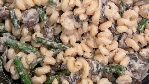 noodles, mushroom, asparagus mixed in vegan alfredo
